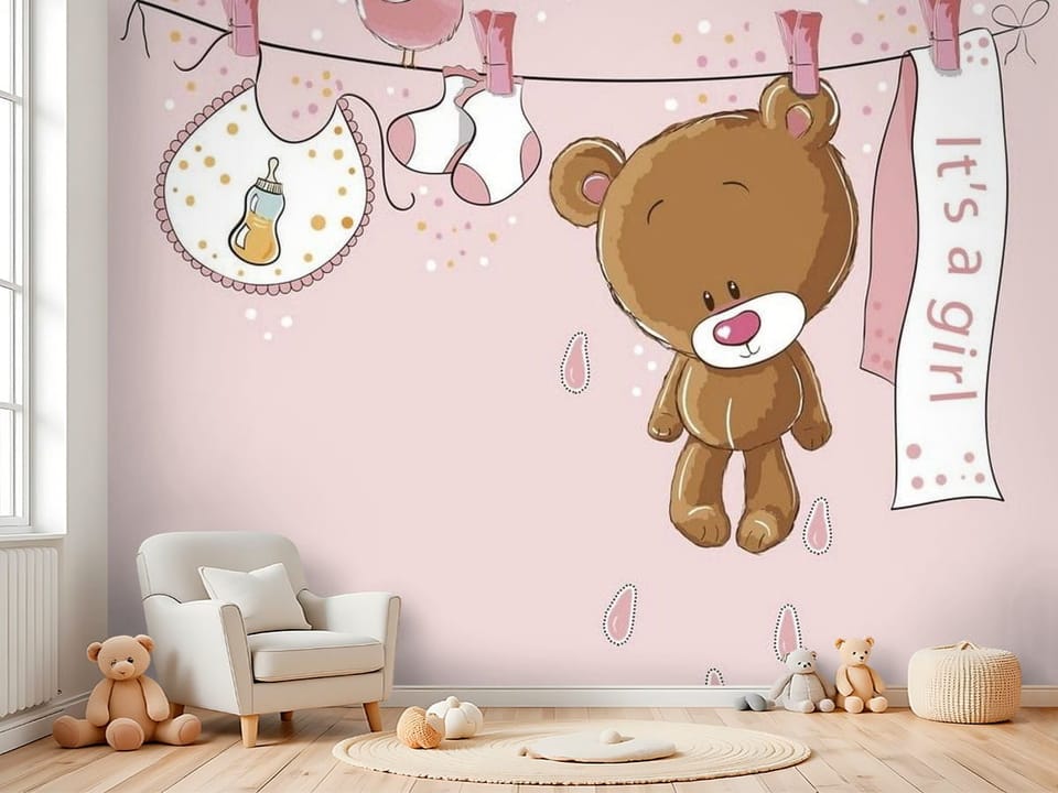 Fototapeta z pluszowym misiem zawieszonym na sznurku i napisem 'It's a girl' - kreatywna przestrzeń do zabawy w pokoju dziecka