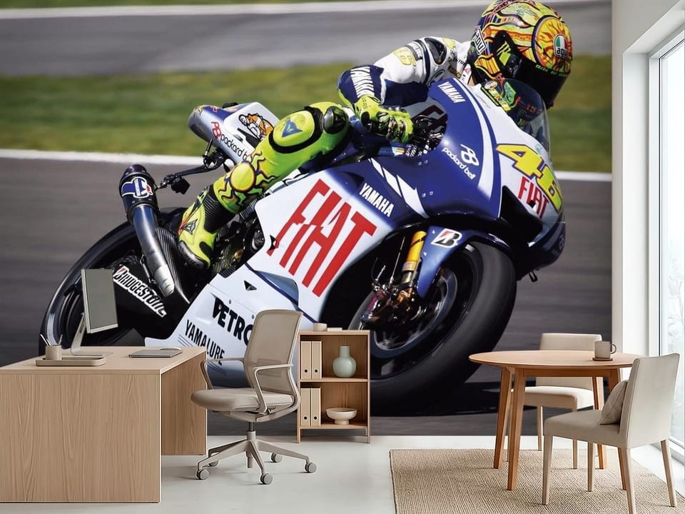 Fototapeta z motocyklem wyścigowym na torze, kierowca w kolorowym kombinezonie - inspiracja do biura w jasnych kolorach