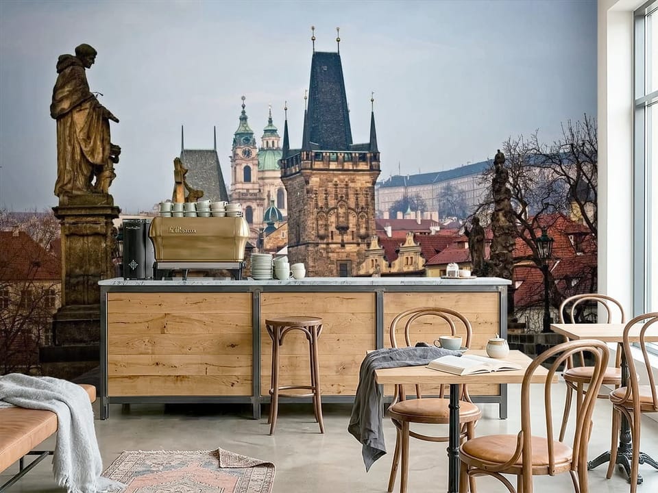 Fototapeta przedstawiająca średniowieczny most z wieżą i kamiennymi posągami. - nowoczesna inspiracja do kawiarni
