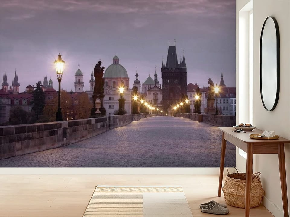 Fototapeta przedstawiająca kamienny most z latarniami i posągami, z wieżami i kopułami w tle. - inspiracji do minimalistycznego przedpokoju