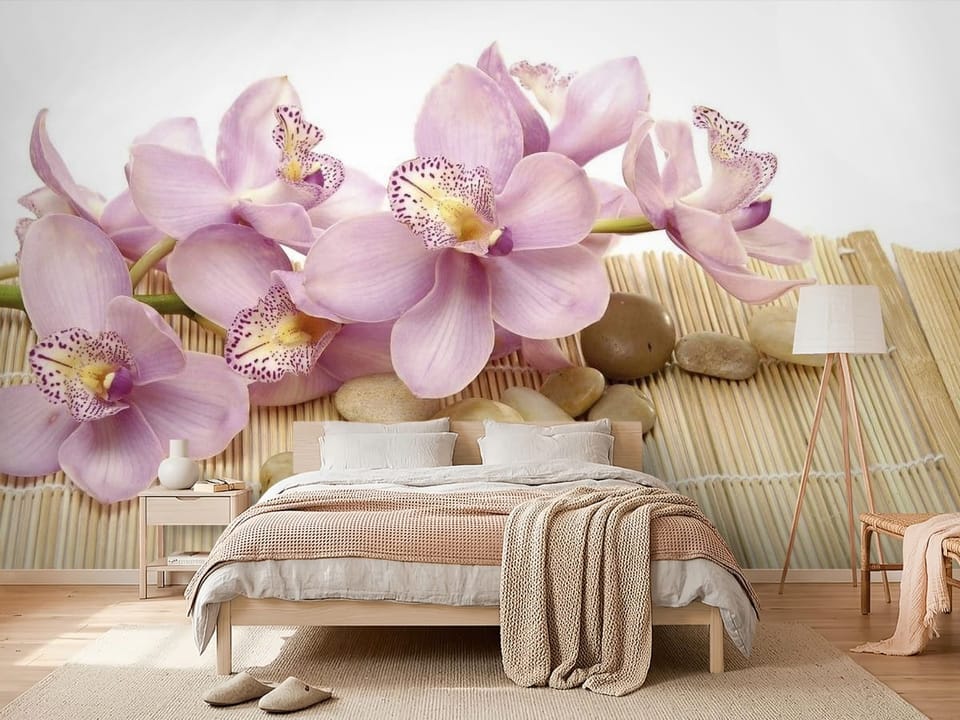 Fototapeta z fioletowymi orchideami na bambusowej macie i kamieniach - nowoczesna aranżacja w sypialni