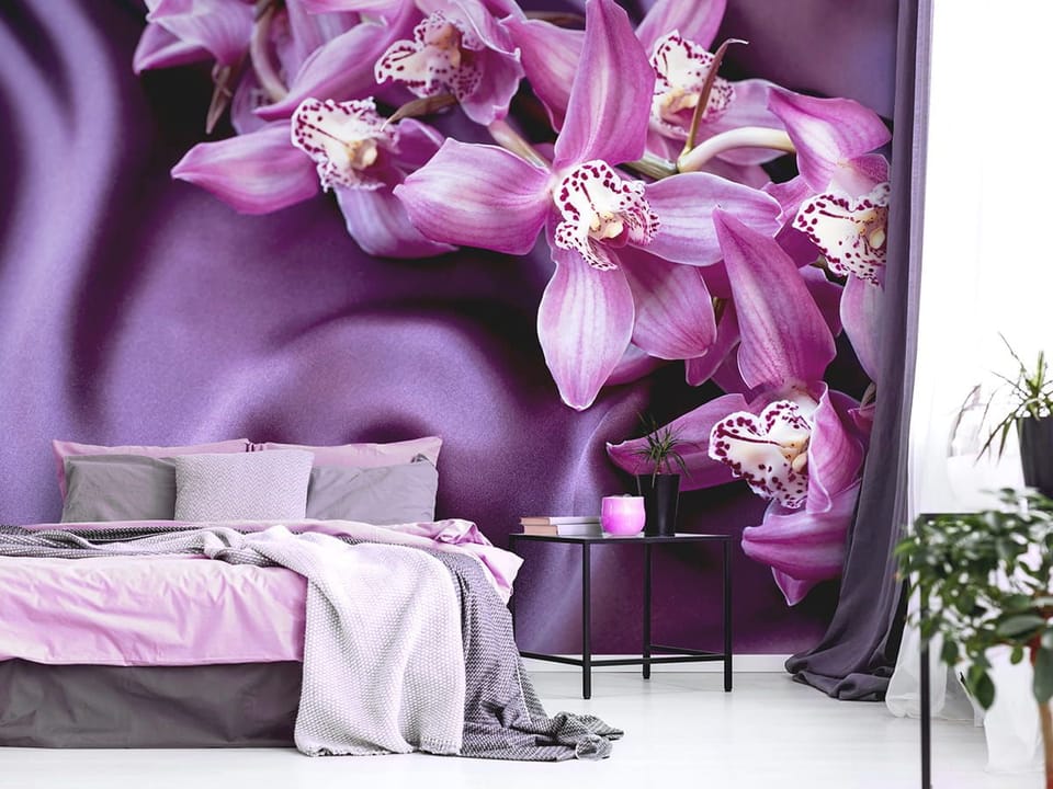 Fototapeta Fioletowe orchidee na tkaninie we wnętrzu sypialni