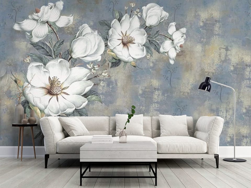 Fototapeta z dużymi białymi kwiatami magnolii i zielonymi liśćmi na niebieskim tle - klasyczny salon w szarych kolorach