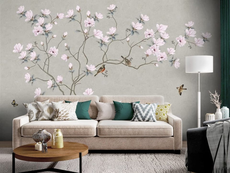 Fototapeta z gałęzią magnolii i różowymi kwiatami na szarym tle - dekoracja ściany za kanapą w salonie
