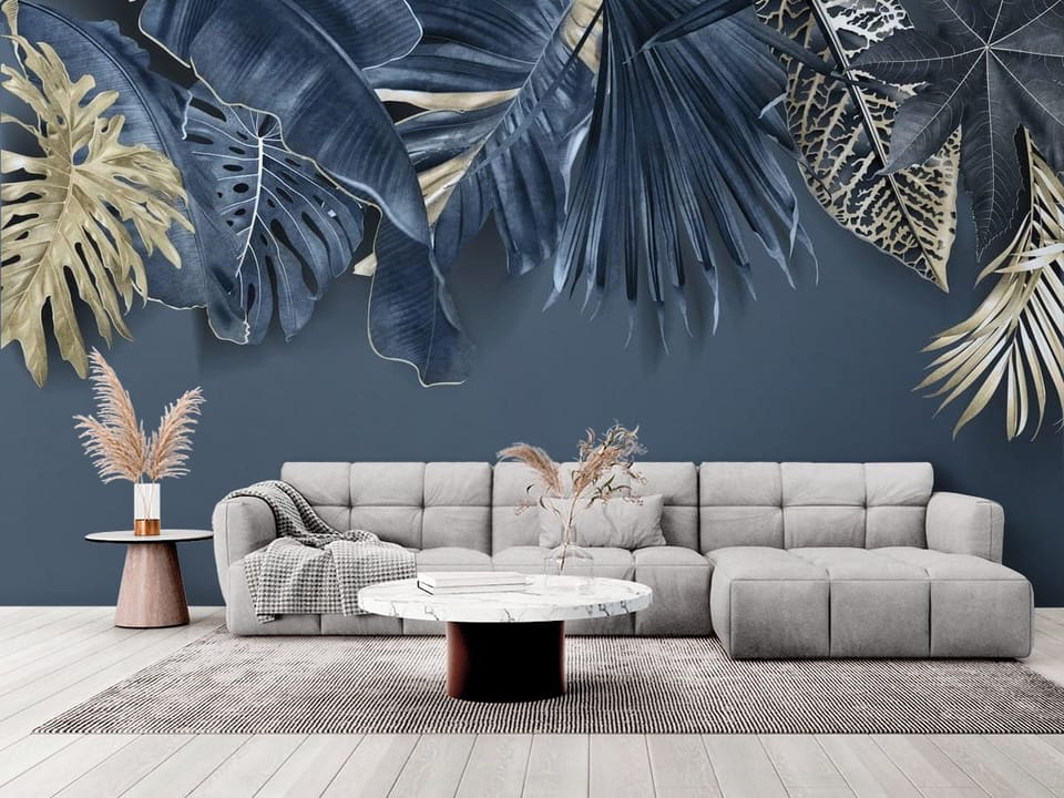 Fototapeta z dużymi liśćmi tropikalnych roślin w odcieniach niebieskiego i beżu - elegancki salon w stylu minimalistycznym