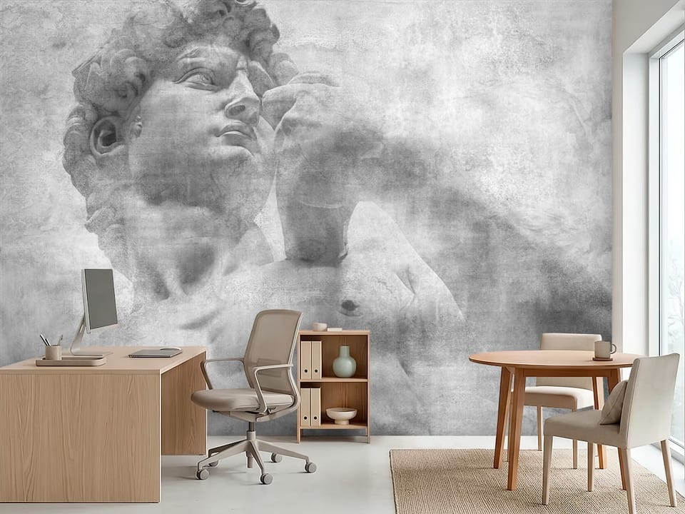 Fototapeta z fragmentem dużej kamiennej rzeźby mężczyzny na szarym tle - inspiracja do biura w jasnych kolorach