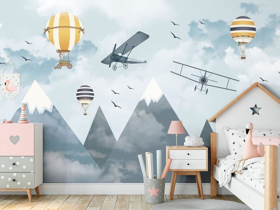 Fototapeta z balonami i samolotami nad ośnieżonymi górami i chmurami - ściana akcentowa w przytulnym pokoju dziecięcym